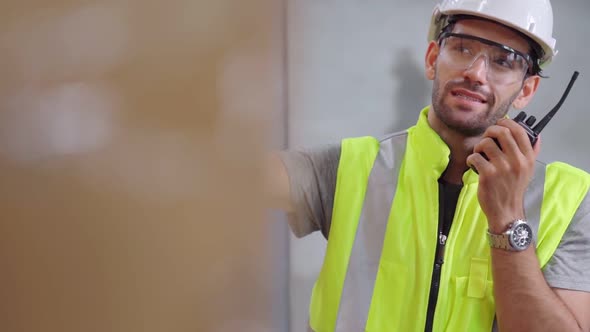 Professional Cargo Worker Talks on Portable Radio to Contact Another Worker alt