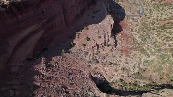 Drone tilts up revealing road on side of cliff in Colorado National Monument