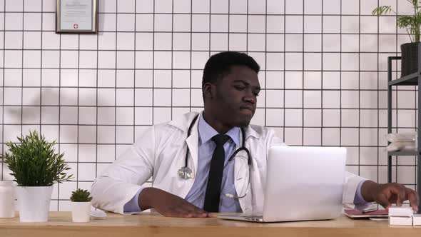 African Pharmacist, Looking at Box of Pills alt