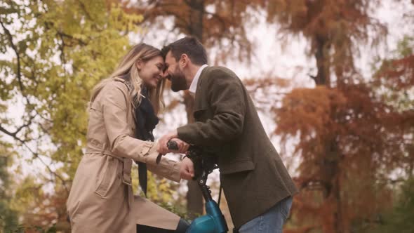 Handsome young couple in the autumn park with electrical bicycle