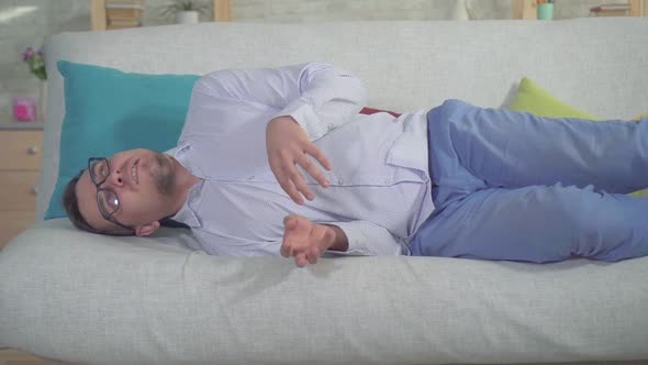 Man with a Smartphone Had an Epileptic Seizure at Home on the Couch Close Up alt