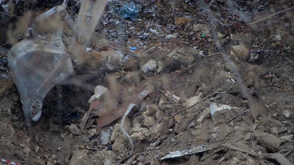 Escavator Digs the Frozen Ground at Snowfall alt