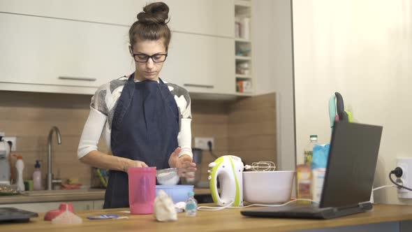 Young Woman in Apron Standing in Kitchen and Prepare Food for Her Family alt