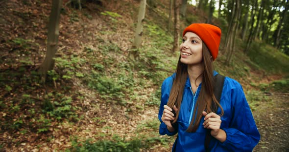 Woman with Backpack Walking in Forest