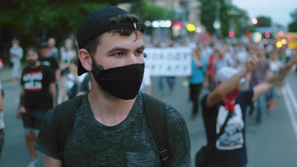 Masked Face of Guy in Crowd of Political Opposition of Coronavirus Restrictions