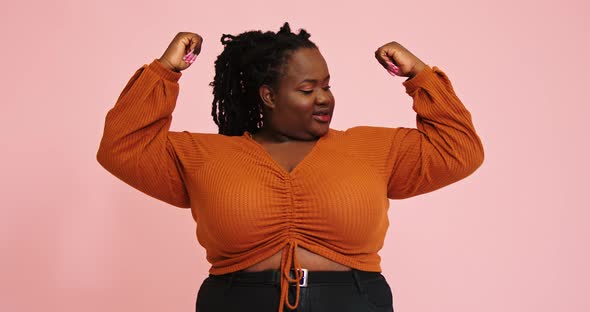 AfricanAmerican Model Raises Hands Up and Looks at Muscles alt