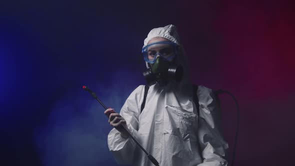 A Person in White Protective Medicine Suit Standing in Smoky Room Holding Cleaning Equipment and alt
