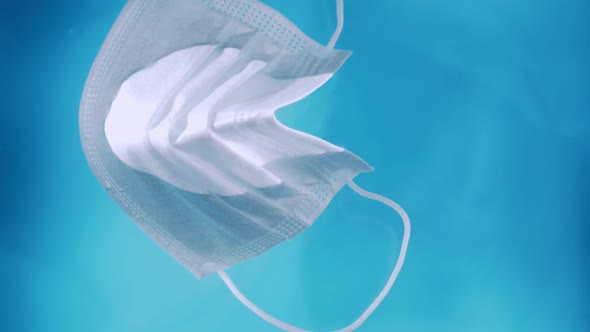 A medical protective mask on the water surface water pollution during the covid-19 crisis with ties alt