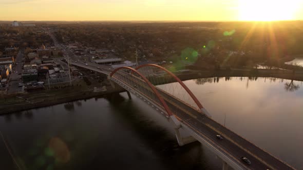 Orbiting aerial view of Hastings Bridge over Mississippi River, as the sun hits the distant horizon alt