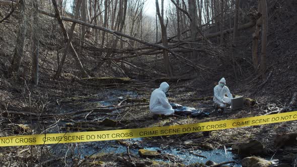 Forensic specialists working in the forest. Crime scene and police concept. alt