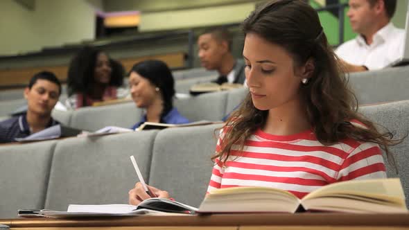 Students in class room throwing paper planes at student. alt