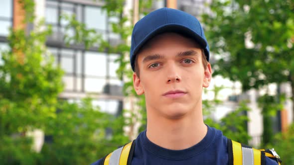 Close Up Serious Young Man Courier Delivery with Thermal Backpack Looking Camera alt