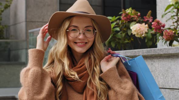 Young Beautiful Girl Walking in City with Bright Gift Bags Woman Shopper Turning Looking at Camera alt