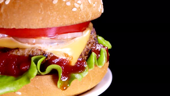 Appetizing burger on a black background. Delicious fast food.