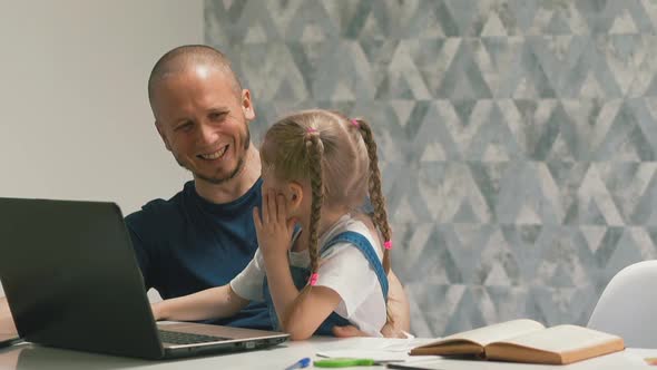 Daddy with Girl Does Homework on Laptop Laughing at Table alt