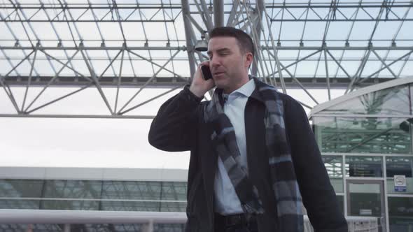 Businessman walking and talking on cell phone at airport