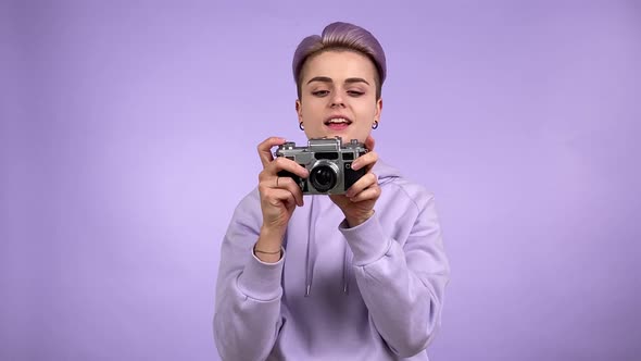 Young Person Taking Pictures Film Camera Isolated on Purple Indoors alt