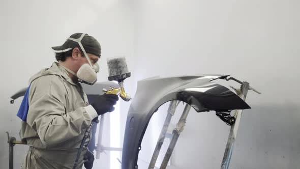 Male Specialist Is Dyeing Metal Detail of Car Body Inside Paint-spraying Booth, alt