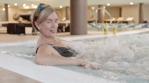 Aged Woman Enjoying Jacuzzi alt
