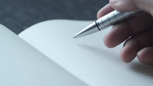 Man's Hand Writing with Pen on Paper