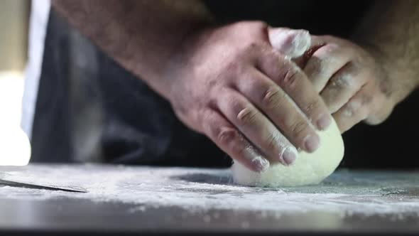 Man kneading dough with his hands to bake sourdough bread