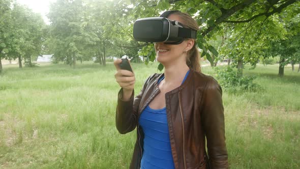 Beautiful Woman In A Virtual Reality Helmet Uses A Virtual App In The Park