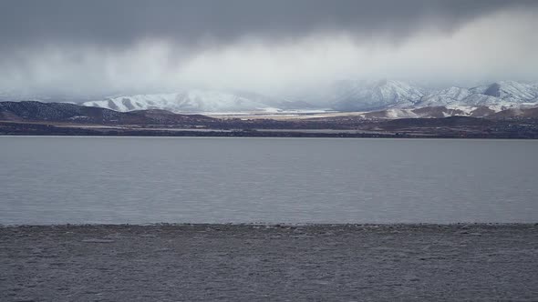 Snow storm in the distance over mountains in winter alt
