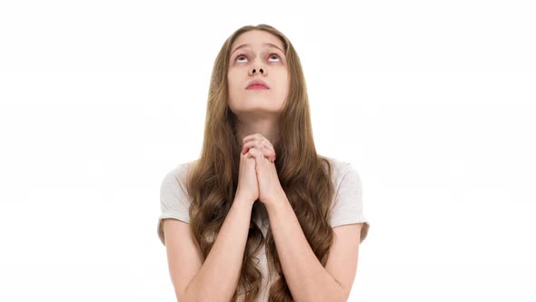 Portrait of Adolescent Woman with No Makeup Looking Up with Keeping Hands in Praying and Begging God alt