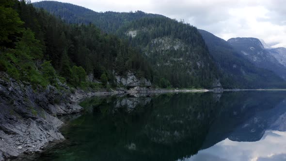 Aerial Fly Along Bank of Gosausee Lake in Low Altitude with Reflection in Upper Austria alt