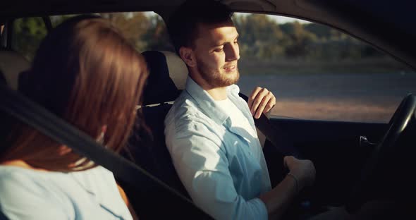 Couple Fastening Seat Belts Sunset