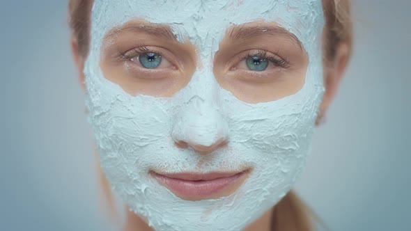 Blonde Model in Studio Makes a Cleansing Facial Mask