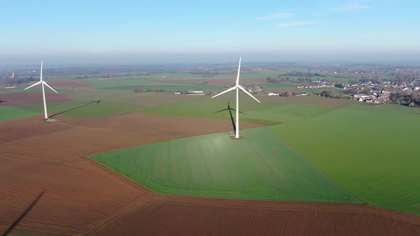 Aerial View of Wind Turbines on Agricultural Fields During Blue Winter Day alt