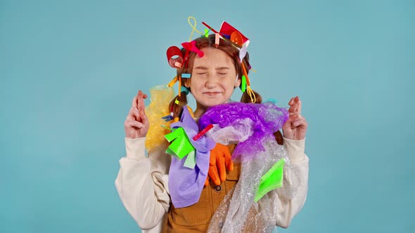 Young girl with garbage on herself doing hope gesture.