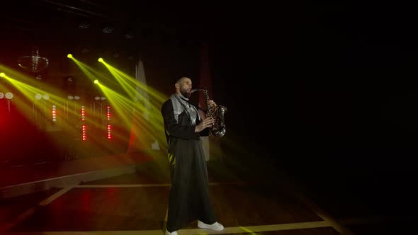 Live Performance of Saxophonist Man with Saxophone Dancing on Concert Musician Stage with Lights alt