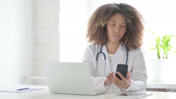 Afrcian Doctor Talking on Phone and using Laptop alt