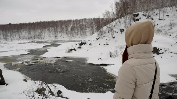 A Girl Stands on Top of a Snowy Mountain with a Selfie of the Park in Her Hands alt