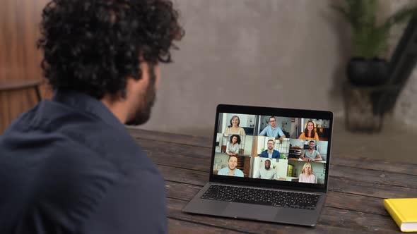Male Employee Involved Video Meeting on Laptop with Diverse Workteam