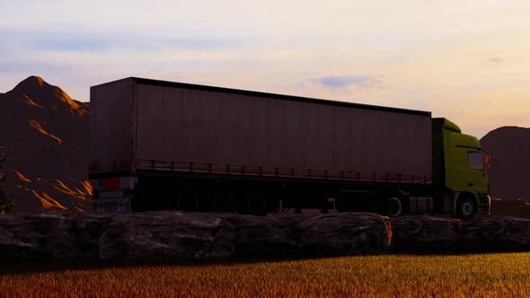 Freight Truck Moving On Rocky Road In Mountainous Area At Sunset