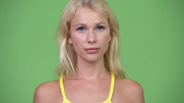 Young Happy Beautiful Woman with Blond Hair Against Green Background