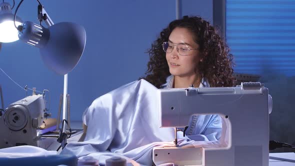 Joyful Girl Seamstress Working on a New Order at Home Studio alt