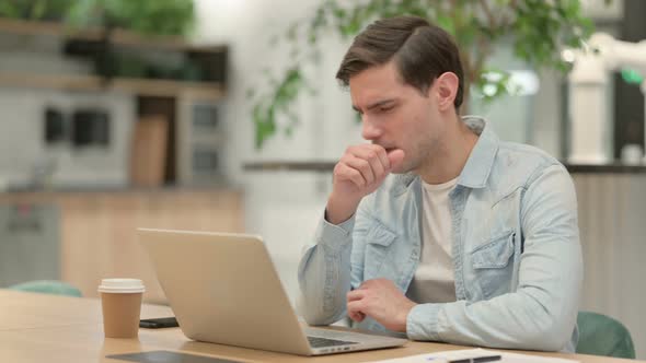 Creative Young Man with Laptop Having Coughing alt