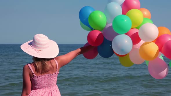 Girl with Balloons on the Beach