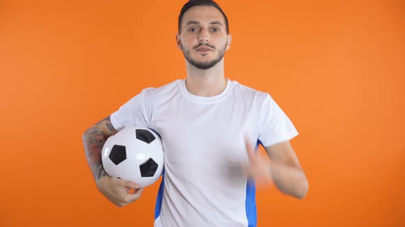  Soccer Ball in Font of White Blue Shirt Soccer Fan Smiling and Succes  alt