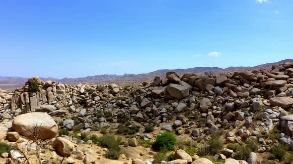 Drone shot flying away from the rocks of Boulder Gardens in Pioneertown, California. alt