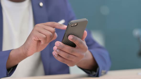 Close Up of Hands of African Businessman Using Smartphone alt
