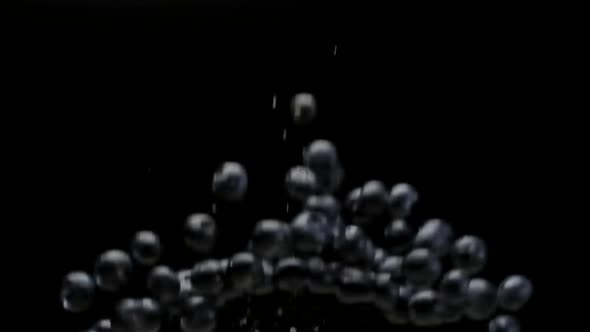 A Blueberries Falling in Slow Motion on a Black Background