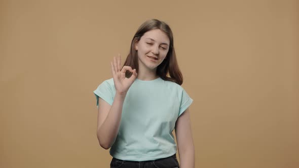 Portrait of Charming Beauty Model Looking at Camera Making Sign Ok and Smiling alt