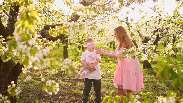 Happiness Mom with Son and Daughter in Spring Flowering Garden alt