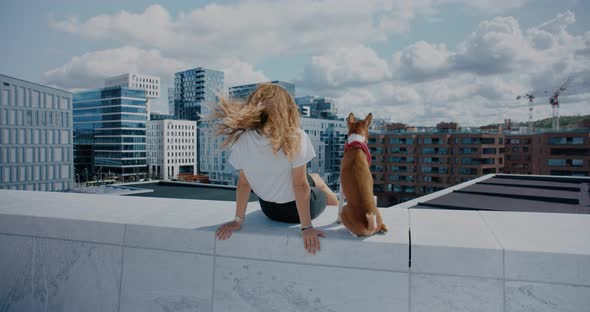 Young Woman and Her Dog Look Over City Skyline alt