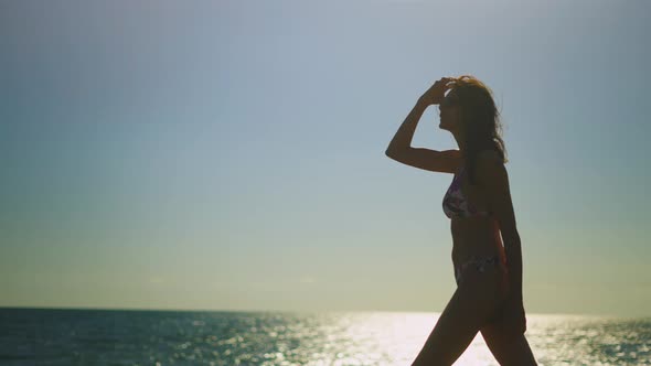 Woman walking along sea coast